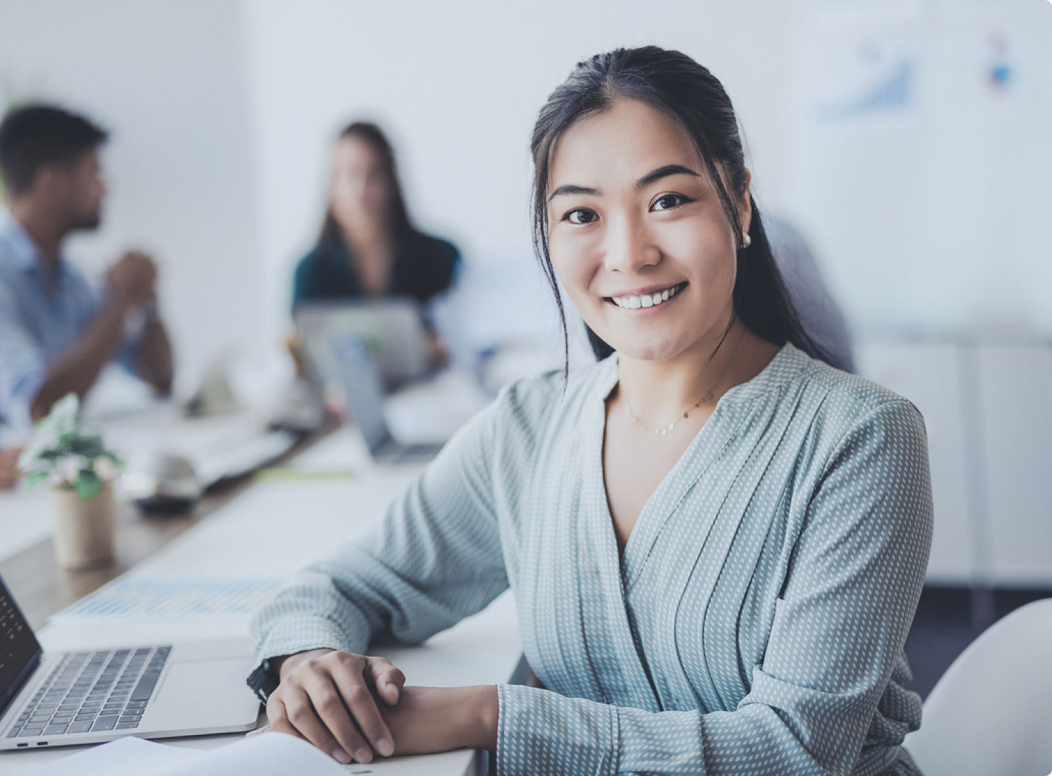 Woman smiling at camera during team meeting