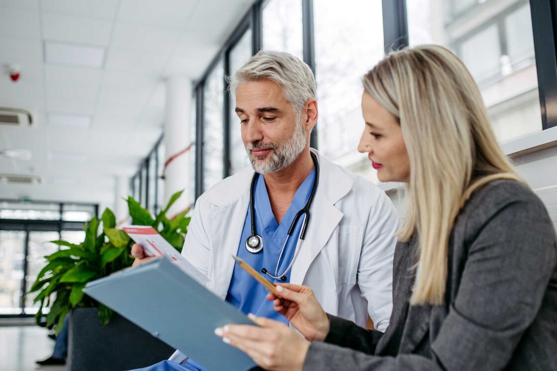 sales rep reviewing documents with doctor in hospital 