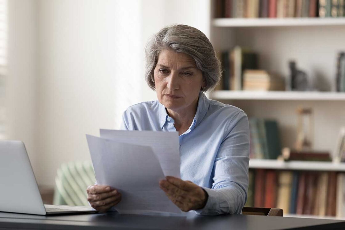 Sales rep reviewing paper documents at desk 