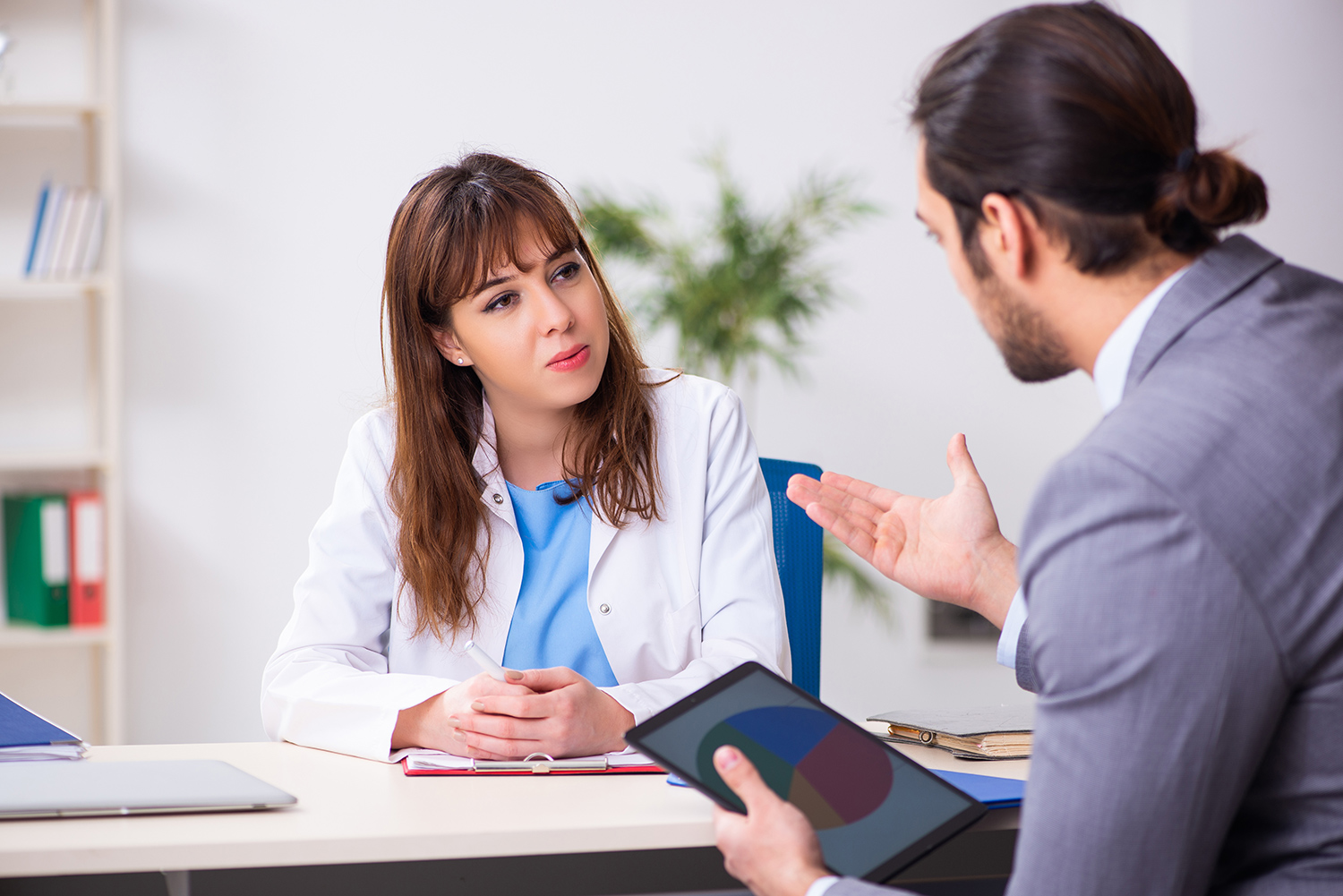 healthcare professional talking with sales rep at table 